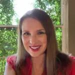 A woman in red shirt smiling for the camera.